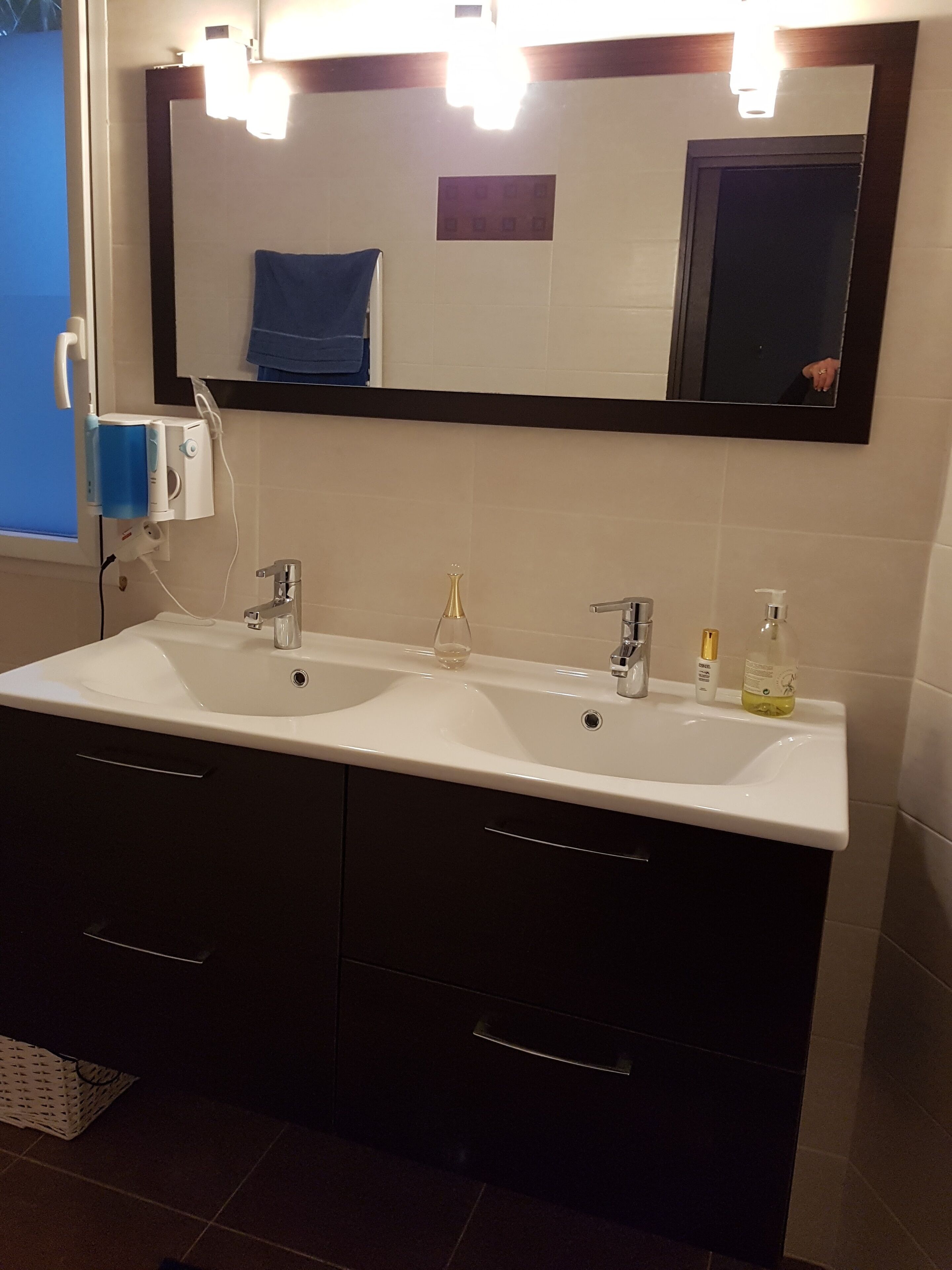 A bathroom with two sinks, a mirror, and a towel rack.