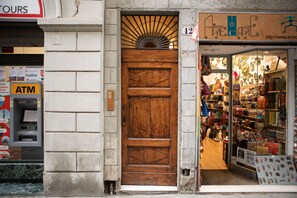 A storefront with a wooden door, an ATM, and a shop selling bags and accessories. - Uffizi Romantic Flat by Mmega (Florence)