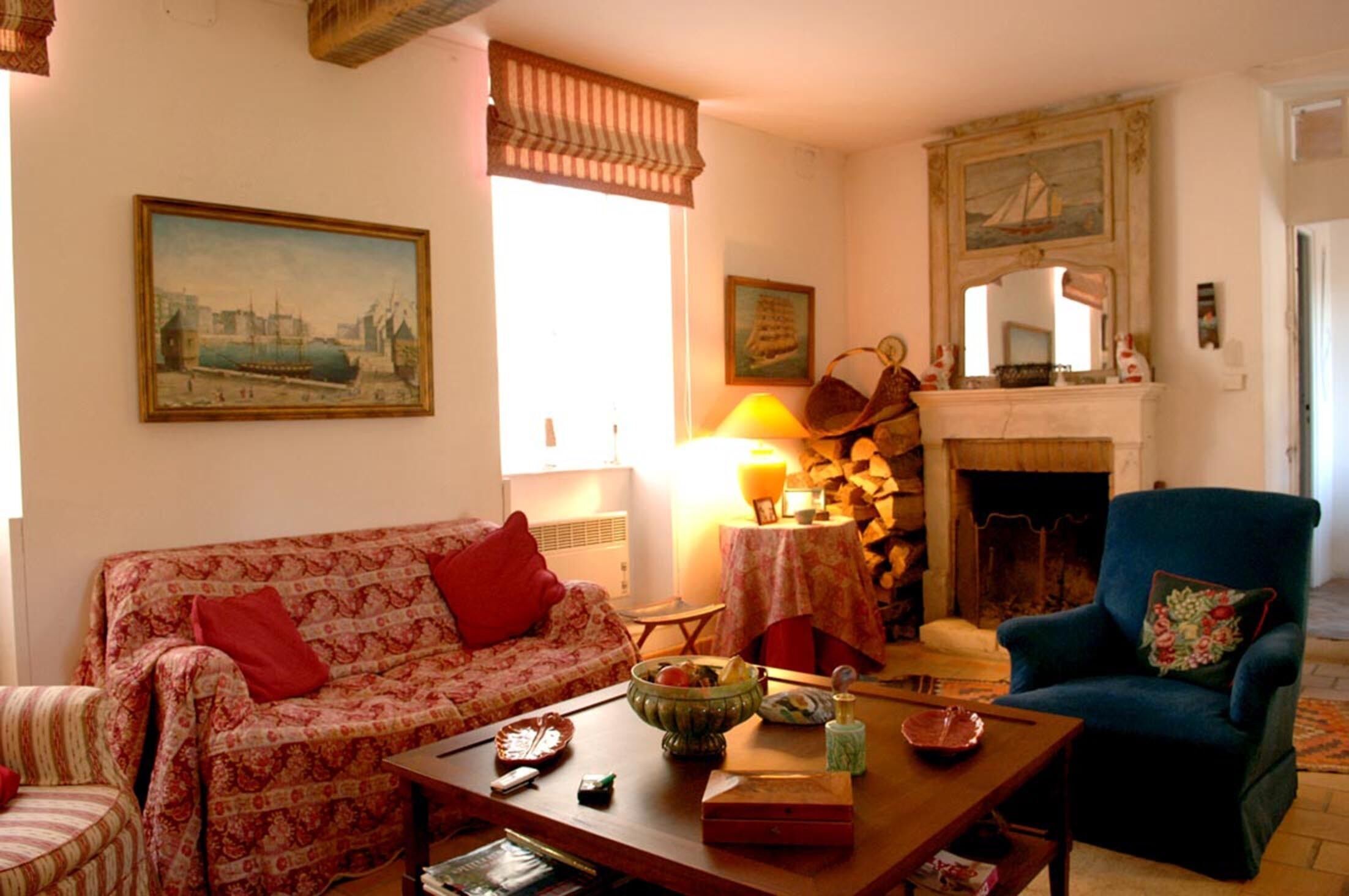 A cozy living room with a sofa, armchair, and a fireplace.