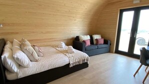 A cozy room with a bed, a sofa, and a large window.
