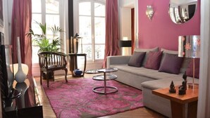 Ein Wohnzimmer mit einer Couch, einem Couchtisch, einem Sessel und einer Zimmerpflanze.