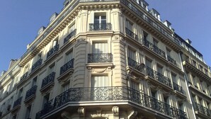 Ein mehrstöckiges Gebäude mit aufwendigen Balkonen und klassizistischen architektonischen Details.