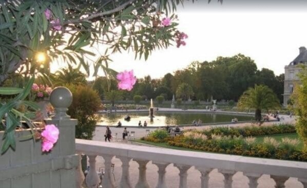 A view of a garden with a fountain, benches, and people walking. - Luxury Apartment - Jardin Du Luxembourg - Quartier Latin (Paris)