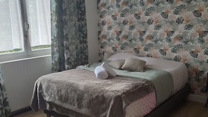 A bedroom with a bed, curtains, a patterned wallpaper, and a round rug. - Mountain spirit, adventure on your doorstep (BARLEST)