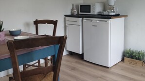 A compact kitchen with a microwave, coffee maker, and a small refrigerator. There is a dining table with chairs and a framed picture on the wall. - Mountain spirit, adventure on your doorstep (BARLEST)