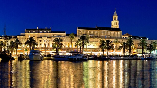A waterfront hotel with multiple balconies, a prominent clock tower, and a marina with boats. - Modern apt Close to Znjan Beach, With big Terrace (Split)