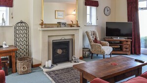 A living room with a fireplace, a television, and a comfortable seating area.