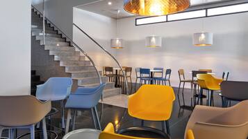 A modern interior with a staircase, seating area, and pendant lighting.