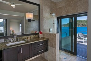 A modern bathroom with a large mirror, dark cabinetry, and a sink. - The Cliff House at Steele Point (West End)
