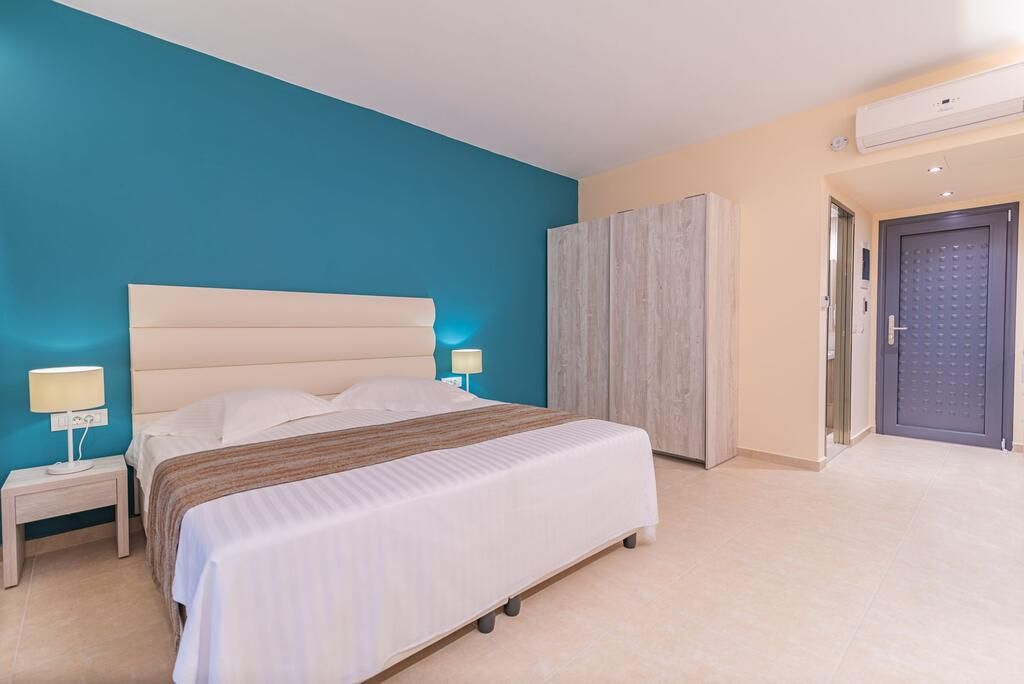 A bedroom with a bed, bedside tables, a wardrobe, and a door.