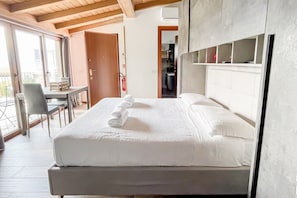 Quarto de hotel com uma cama, uma mesa e uma cadeira.