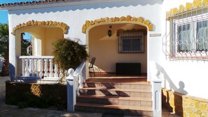 A two-story house with a white exterior, a balcony, and a staircase leading to the entrance. - "La Siesta"@MARISOL: 330m to the beach, private pool, A/C, WiFi, dog beach. (Riumar)