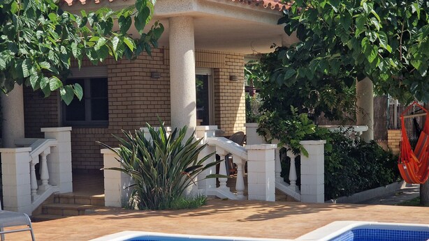 A swimming pool with a tiled edge, a brick building with a balcony, and a hammock. - "Maria Luise"@MARISOL: 600m to the beach, private pool, A/C, WiFi, dog beach. (Riumar)