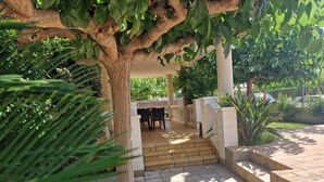 A covered outdoor seating area with stone flooring and a pergola overhead. - "Maria Luise"@MARISOL: 600m to the beach, private pool, A/C, WiFi, dog beach. (Riumar)