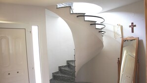 A staircase with a unique curved design, a wooden mirror, and a white door. - "Maria Luise"@MARISOL: 600m to the beach, private pool, A/C, WiFi, dog beach. (Riumar)
