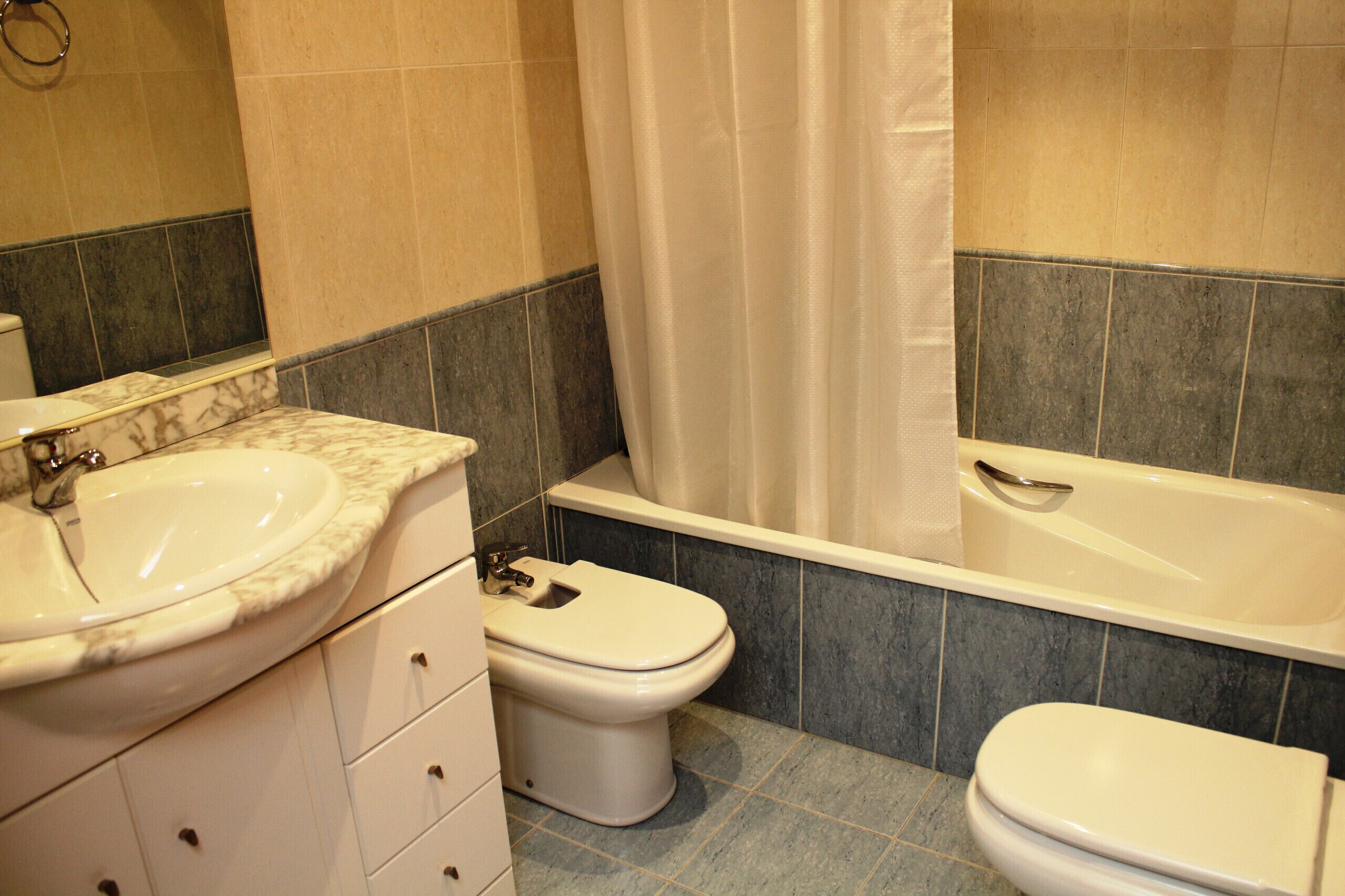 A bathroom with a sink, toilet, and bathtub.