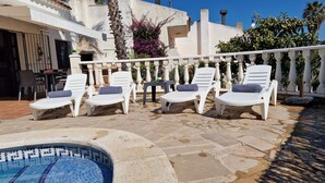 Ein Poolbereich mit Liegestühlen und einem gefliesten Pool.