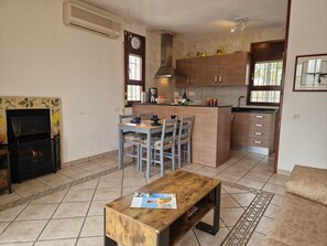 Una cocina compacta con comedor, chimenea y una pequeña mesa de centro.