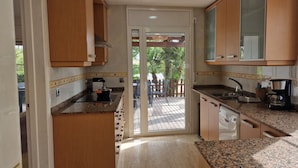 Una cucina con piani di lavoro in granito, mobili in legno e vista su un patio esterno.