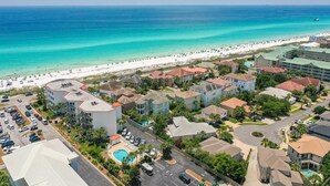A coastal residential area with beachfront properties, a swimming pool, and a beach with people and vehicles. - Crystal View 203 3 bedroom/  3 bath unit Beach service great view SO MUCH SPACE (Miramar Beach)