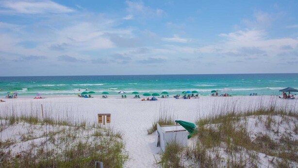 A beach with white sand, green umbrellas, and a clear blue sky. - Crystal View 203 3 bedroom/  3 bath unit Beach service great view SO MUCH SPACE (Miramar Beach)