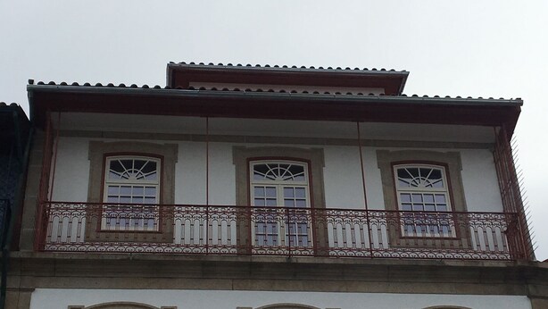 A building with three windows on the upper floor and three on the lower floor, each with a decorative arch.
