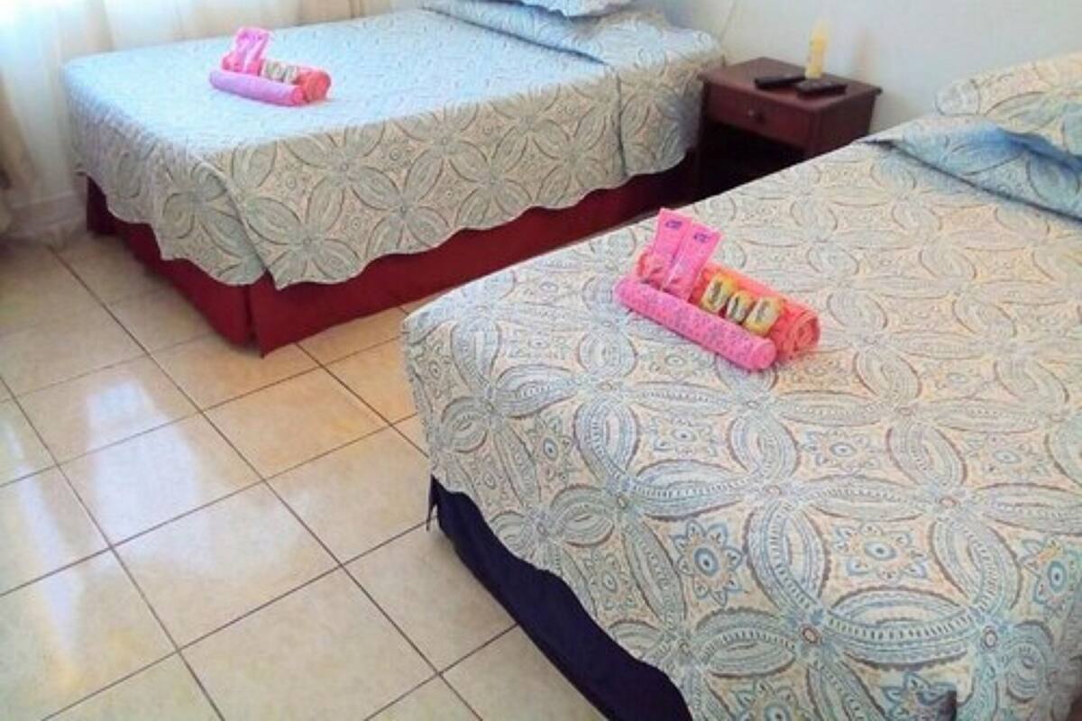 Two twin beds with patterned bedding and a nightstand with a lamp.