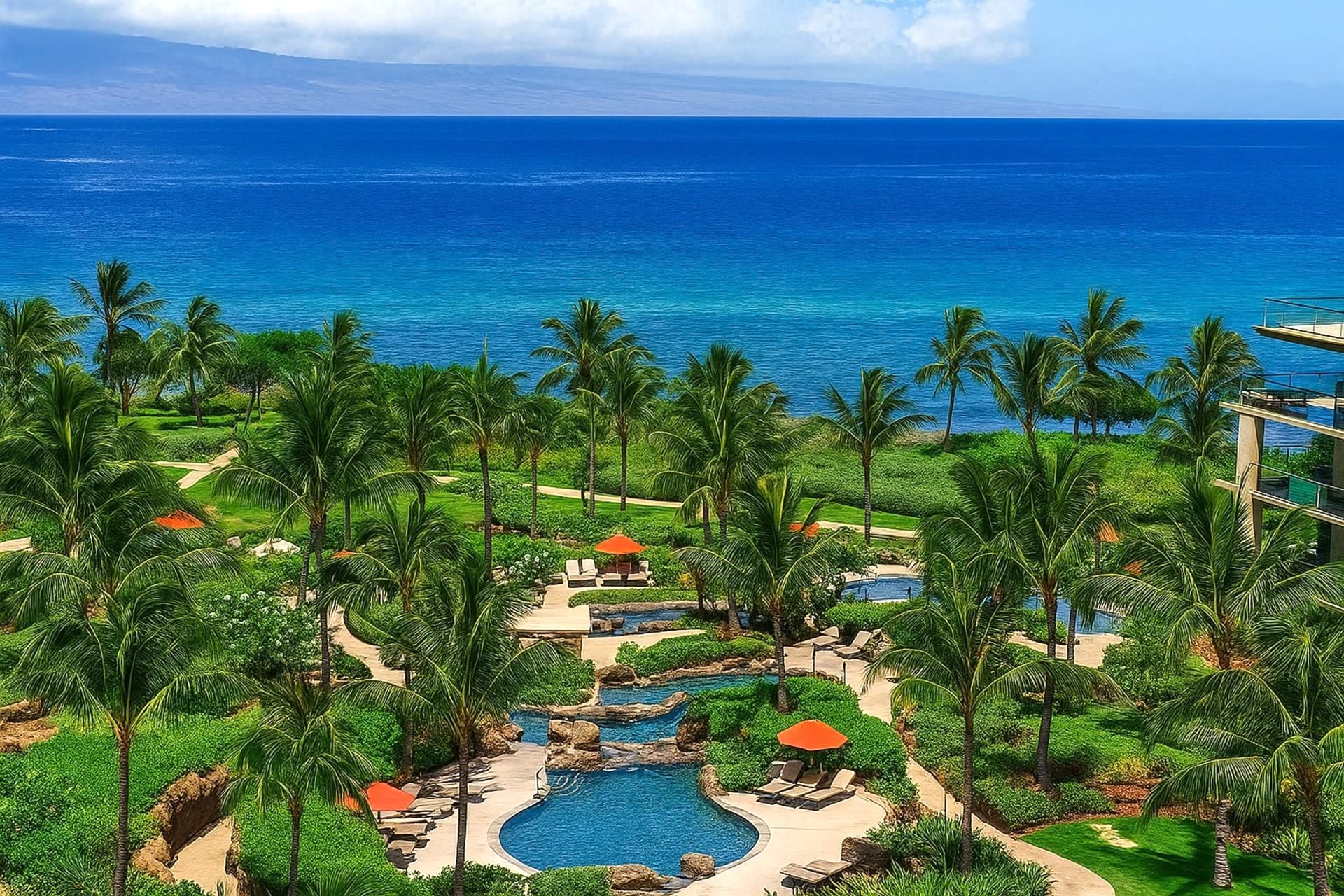 A resort with a swimming pool, palm trees, and a view of the ocean.