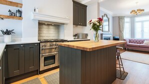 Una cucina moderna con isola centrale, forno integrato, microonde e mobili scuri.