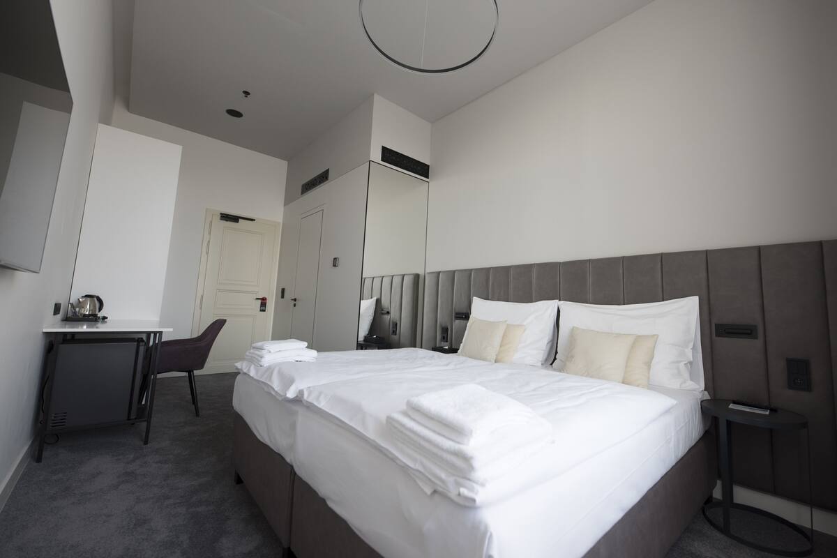 Una habitación de hotel moderna con una cama grande, un escritorio y una silla.
