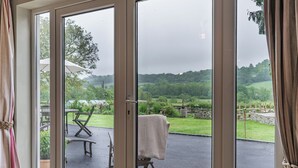 A room with a sliding glass door leading to an outdoor patio with a table and chairs. - 4 bedroom accommodation in Llandeilo (Llandeilo)