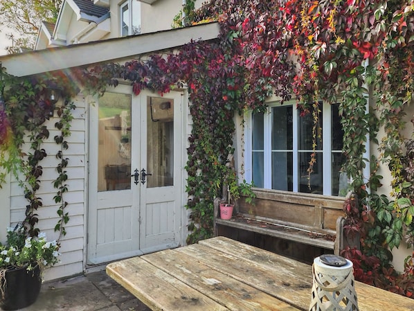 A wooden table, a white door, and a window with a view of the sky.