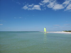 Enjoy a serene beach experience with clear waters and a sandy shore, perfect for a relaxing day.