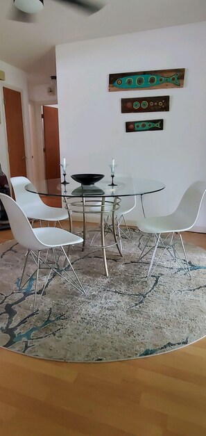 Enjoy meals in this stylish dining area with a round table, four chairs, and a cozy rug.