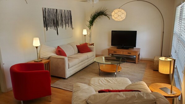 Relax in this stylish living room with a sofa, armchair, and flat-screen TV.