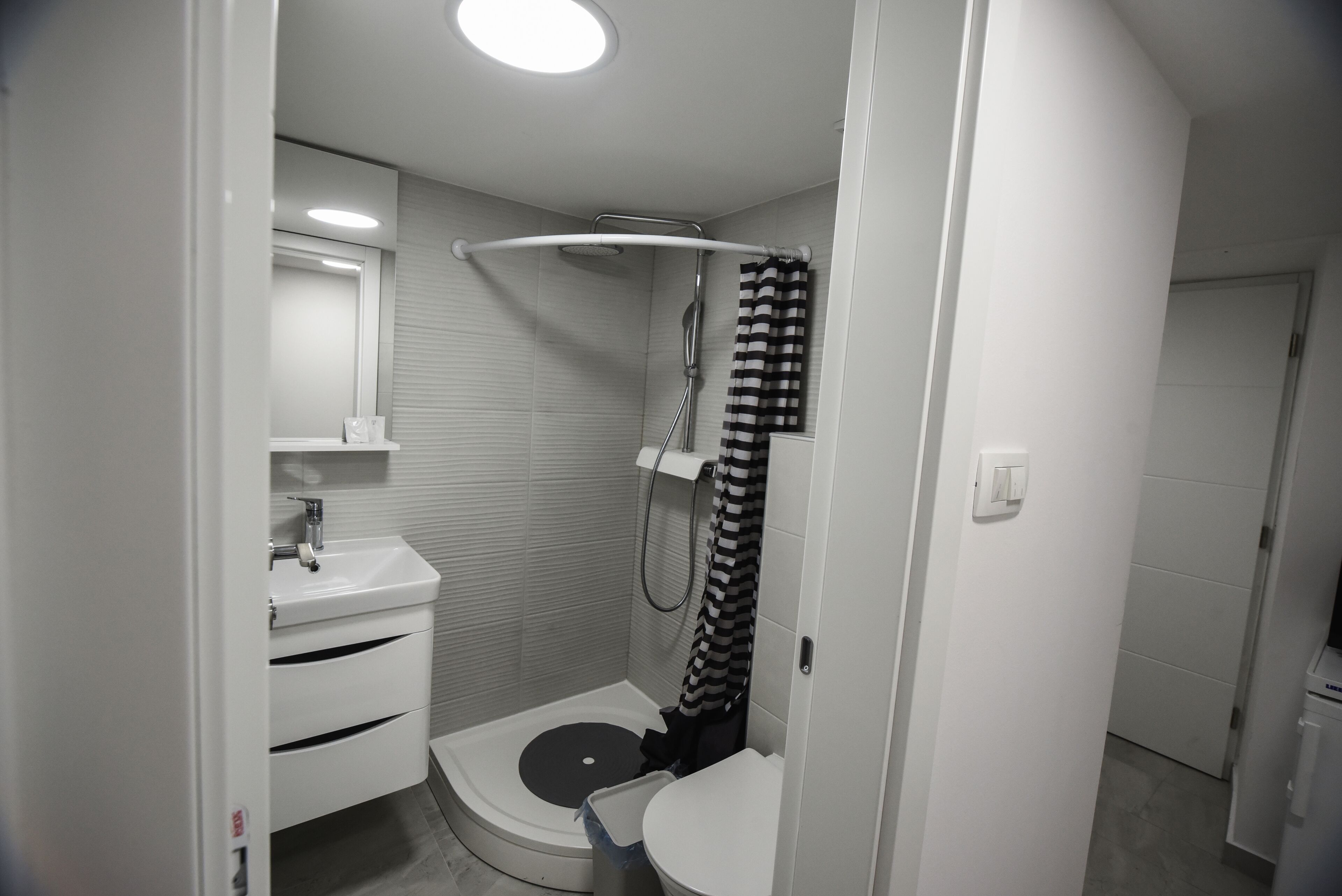 A compact bathroom with a shower, toilet, and sink.