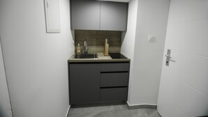 A compact kitchen with a sink, cabinets, and a countertop. - Studio Apartment Direkt am Strand (Baška)