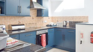 Una cucina moderna con mobili blu, un fornello a gas, un forno a microonde e un tostapane.