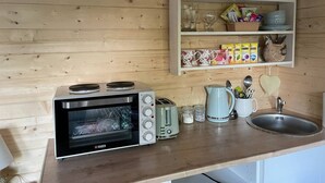 Une cuisine compacte équipée d’un four Haden, d’un grille-pain, d’une bouilloire et d’un évier.