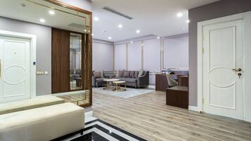 A modern living room with a sofa, coffee table, and a large mirror.