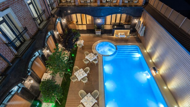 Un espace piscine aménagé sur le toit, avec des chaises longues et un jacuzzi.