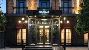 Un bâtiment en briques avec une enseigne lumineuse indiquant « Mayfair » et une entrée en verre.