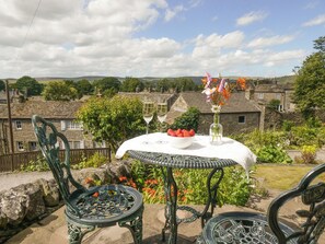 A table with a white tablecloth, a bowl of strawberries, a vase with flowers, and two glasses of wine. - 2 bedroom accommodation in Grassington (Grassington)