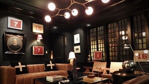 A cozy lounge area with leather sofas, a coffee table, and framed pictures on the walls. - Truitt Hotel (Kansas City)