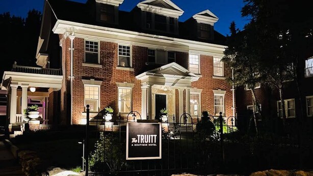 A large, two-story brick building with a prominent entrance and a sign that reads "The TRUITT A BOUTIQUE HOTEL." - Truitt Hotel (Kansas City)
