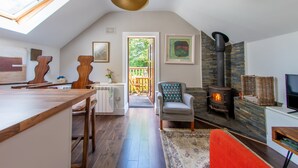 Un espacio habitable tipo loft acogedor, con comedor, chimenea y televisor.