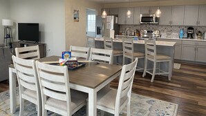 A modern kitchen with wooden cabinets, a central island, and pendant lighting. - Perfect Location for your Beach/Lake MI stay!  You'll Love This Beautiful Home! (New Buffalo)