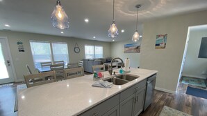 A spacious kitchen with a large island, stainless steel appliances, and pendant lighting. - Perfect Location for your Beach/Lake MI stay!  You'll Love This Beautiful Home! (New Buffalo)
