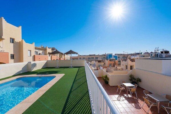 A rooftop pool area with a clear blue sky, a swimming pool, and outdoor seating. - Medina Torrecilla Beach by Casasol (Nerja)