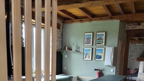 A rustic kitchen with a stone island, wooden beams, and framed pictures on the wall. - House in the countryside near Omaha Beach! Pets allowed (Mandeville-en-Bessin)